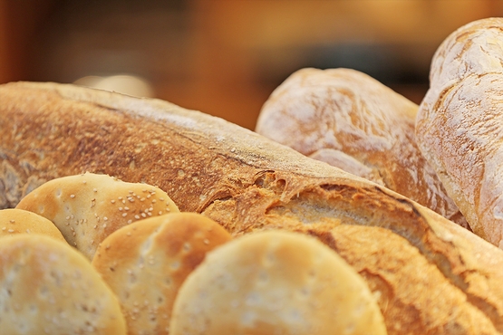 Nahaufnahme eines Brotkorbes mit einem Baguette und Dementer-Fladen
